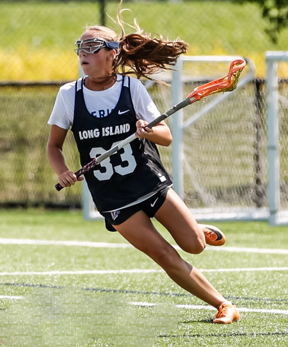 A high-school lacrosse player drives upfield during a match.